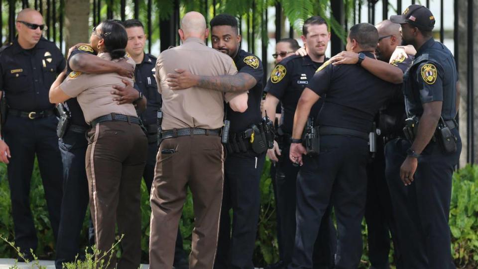 Miami-Dade police officers and North Miami police officers comfort each other after police escorted the coffin of Miami-Dade Police Detective Cesar Echaverry from Jackson Memorial Hospital to the Miami-Dade County Medical Examiner’s Department on Friday, Aug. 19, 2022. Echaverry was shot in the head in a shootout with an armed robbery suspect Monday night. He died Wednesday night when doctors removed the ventilator that had been keeping him alive in Miami.