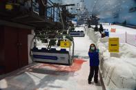 FILE - In this May 27, 2020 file photo, an employee at Ski Dubai inside the Mall of the Emirates waits for skiers near the chair lift in Dubai, United Arab Emirates. The global energy transition is perhaps nowhere more perplexing than in the Arabian Peninsula. Gulf Arab states are privately and publicly advocating for carbon capture technologies rather than a rapid phasing out of burning fossil fuels. (AP Photo/Jon Gambrell, File)