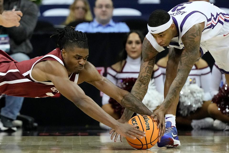 Oklahoma guard Otega Oweh, left, and TCU guard Avery Anderson III (3) compete for a loose ball during the second half of an NCAA college basketball game Wednesday, March 13, 2024, in Kansas City, Mo. TCU won 77-70. (AP Photo/Charlie Riedel)