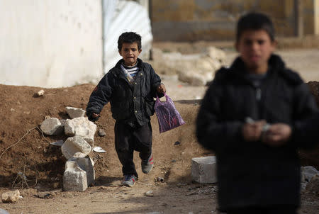 A student carries belongings in a plastic bag as he arrives to attend a class at the 'Aisha Mother of the BelieversÕ school which was recently reopened after rebels took control of al-Rai town from Islamic State militants, Syria January 16, 2017. Picture taken January 16, 2017. To match story REUTERS/Khalil Ashawi