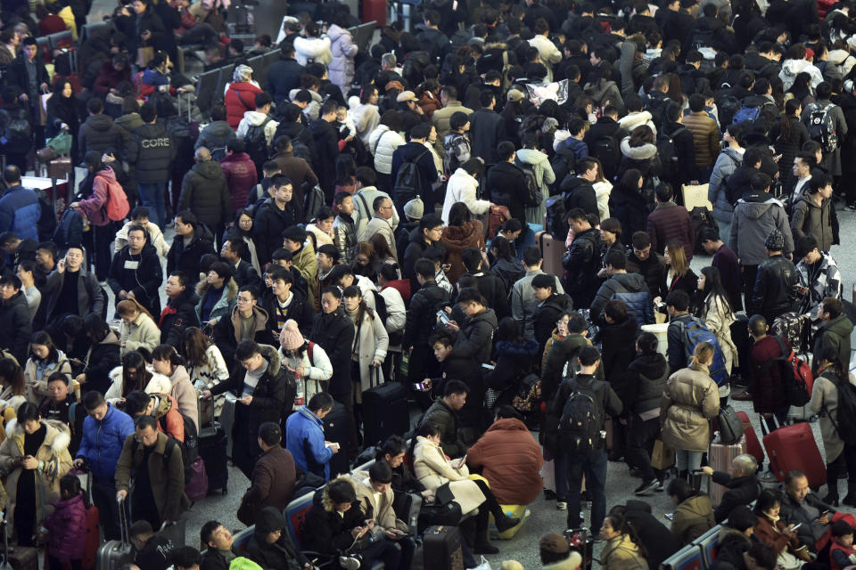 In this Jan. 28, 2019, photo, Chinese travelers wait for their trains at a railway station in Hangzhou in east China's Zhejiang province. The world's largest annual migration has began in China with millions of Chinese are traveling to their hometowns to celebrate the Lunar New Year on Feb. 5 this year which marks the Year of the Pig on the Chinese zodiac. (Chinatopix via AP)