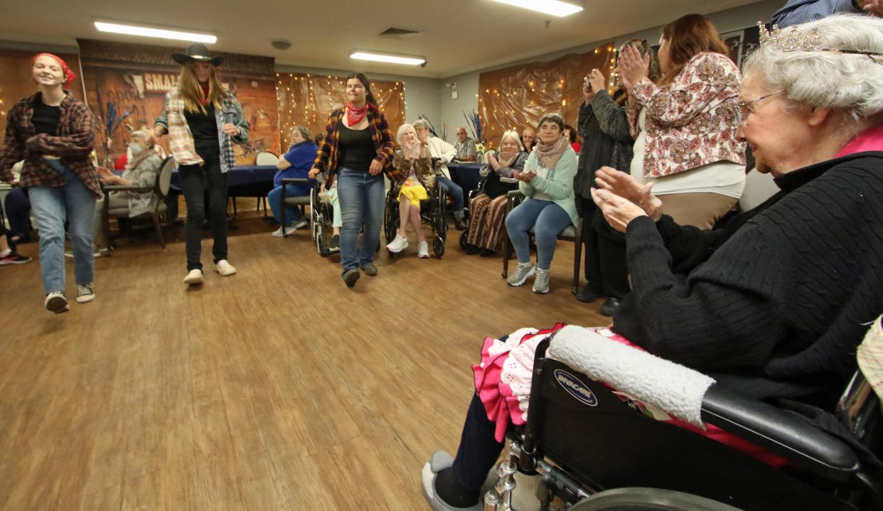 Lorene Summey claps her hands as a trio of young women line dance during her 105th birthday party Friday evening, Nov. 18, 2022, at Somerset Court of Cherryville, North Carolina.