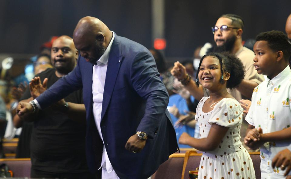 Pastor John Gray reacts to the moment and dances with his children at his side before taking the stage during a Sunday morning service at Relentless Church in Greenville.