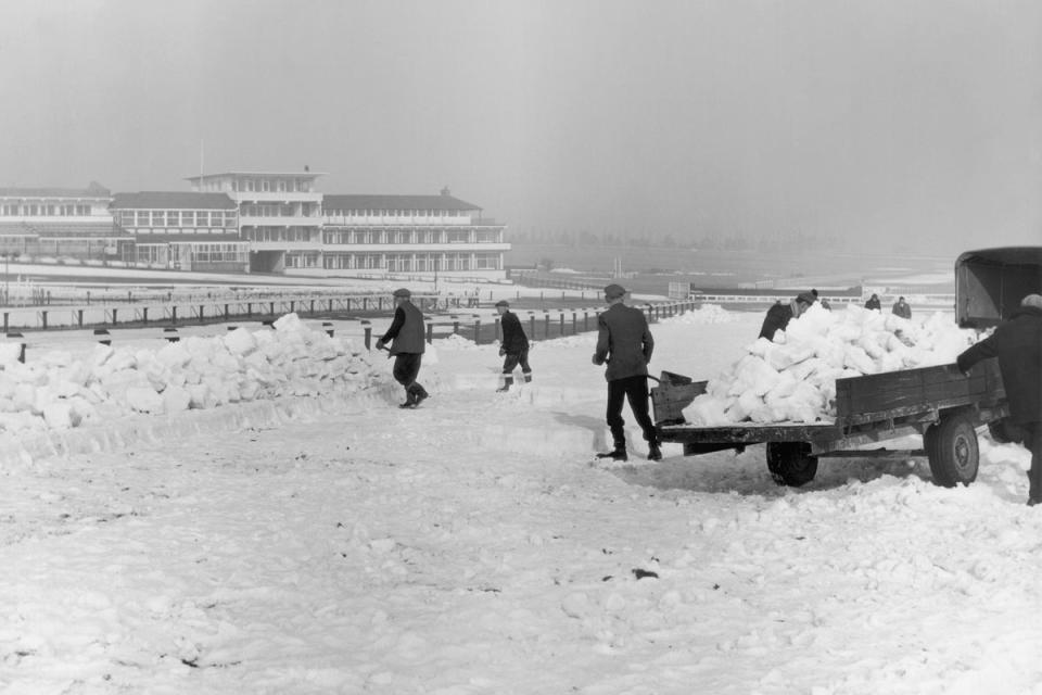 1963:  Teams of men clear the snow from Cheltenham racecourse before the venue reopens on March 12th. The work has to be done by hand, since machines would damage the turf. (Fox Photos/Getty Images)