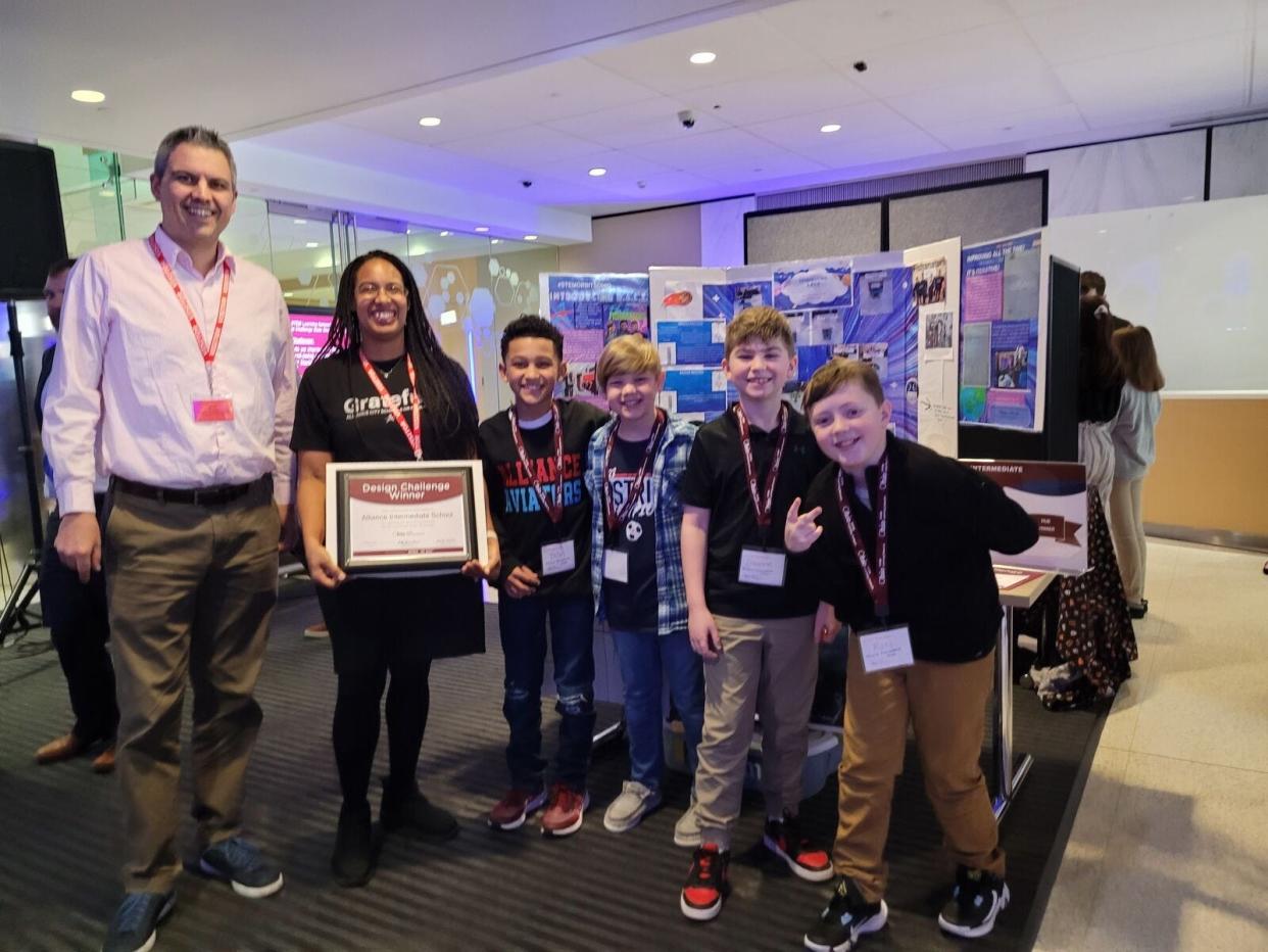 Aaron Weaver of NASA Glenn Research Center in Cleveland, left, and LaToya Gispert, second from left, stand with Fishanator team members, from left, Talen Henderson, Andrew Horning, Dawson Sedei and Ross Gardner, Alliance Intermediate School students who won a state title in their division of the Ohio STEM Learning Network #STEMorbitsOhio design challenge.