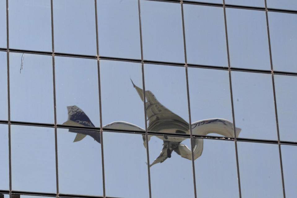 In this Jan. 15, 2013 photo, the windows of a building reflect the image of a plane approaching the Mariscal Sucre airport for landing in Quito, Ecuador. Mariscal Sucre airport sat amid cornfields when it was christened in 1960, and on Feb. 19, the airport will close and a new airport will be built. The runway will become a grassy esplanade, and a flurry of construction is anticipated nearby. The newly revised code will allow for buildings as high as 40 stories, up from the current four. (AP Photo/Dolores Ochoa)