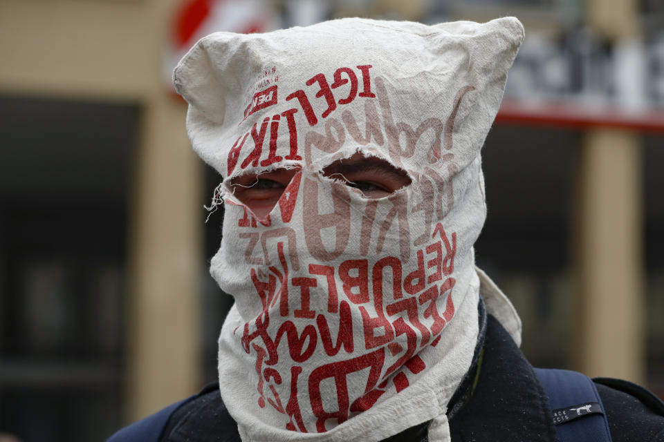 A man wears a bag over his head instead of a mask as demonstrators gather to protest the COVID-19 preventive measures downtown Prague, Czech Republic, Wednesday, Oct. 28, 2020. Coronavirus infections in the Czech Republic have again jumped to record levels amid new restrictive measures imposed by the government to curb the spread. (AP Photo/Petr David Josek)