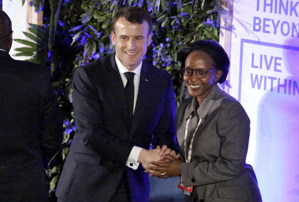 France's President Emmanuel Macron, center, shakes hands with Joyce Msuya, Deputy Executive Director of the United Nations Environment Programme, center-right, at the United Nations Environment Assembly in Nairobi, Kenya Thursday, March 14, 2019. Macron said at the conference Thursday that energy resources like coal that fueled industrialization in the developed world are no longer viable because they create pollution. (AP Photo/Khalil Senosi)