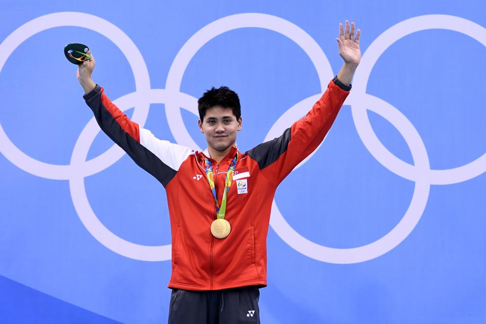 Singapore's Schooling Joseph poses with his gold medal on the podium of the Men's 100m Butterfly Final during the swimming event at the Rio 2016 Olympic Games at the Olympic Aquatics Stadium in Rio de Janeiro on August 12, 2016.   / AFP / GABRIEL BOUYS        (Photo credit should read GABRIEL BOUYS/AFP via Getty Images)