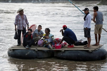 Migrants and locals cross the Suchiate river on a raft from Tecun Uman, in Guatemala, to Ciudad Hidalgo, as seen from Ciudad Hidalgo