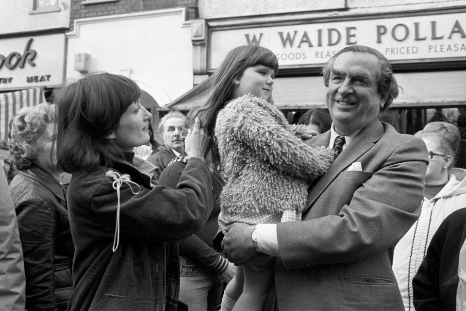 Chancellor of the Exchequer Denis Healey finds a friend in four year old Nina Westover when he toured the Ilford North constituency today in support of Labour's by-election candidate Mrs Tessa Jowell (left).   (Photo by PA Images via Getty Images)