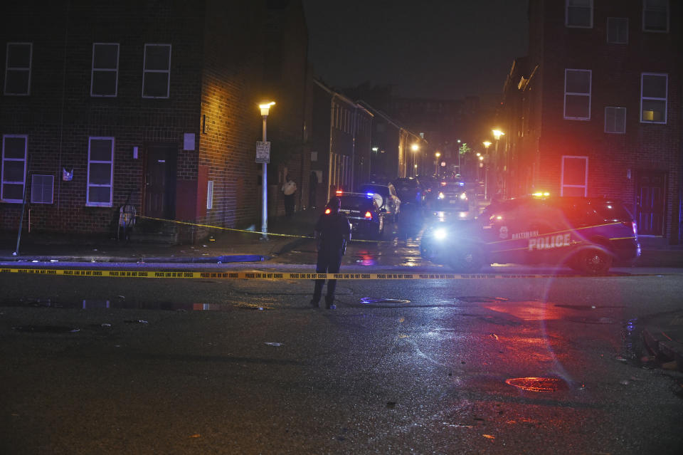 Baltimore City police officers block off the scene of a shooting in Baltimore on Sunday, Sept. 23, 2018. The shootout between a man in a violence-prone Baltimore district and a police officer taking part in a crime suppression initiative has left the officer wounded and the suspect dead Sunday evening, Baltimore's interim police chief said. (Kenneth K. Lam/The Baltimore Sun via AP)