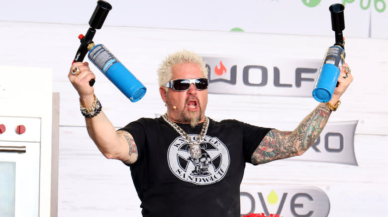 Guy Fieri holding blowtorches