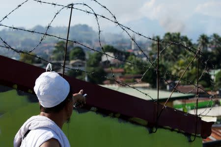 A man watches from a rooftop during the Philippines army airstrike as government troops continue their assault against insurgents from the Maute group in Marawi city June 27, 2017. REUTERS/Jorge Silva