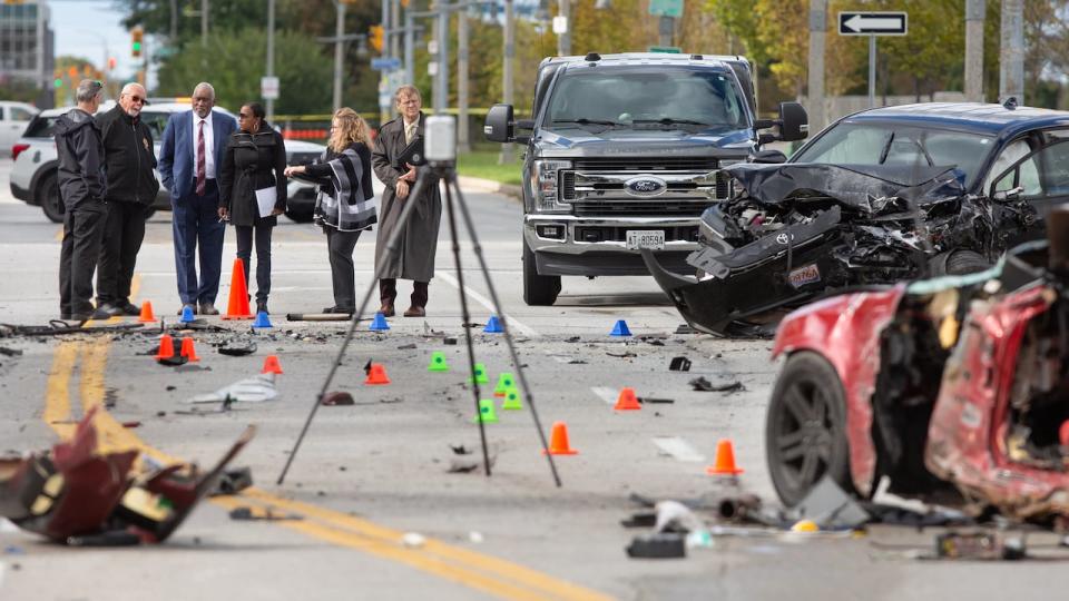 Investigators examine the scene of a three-vehicle crash on Riverside Drive East.