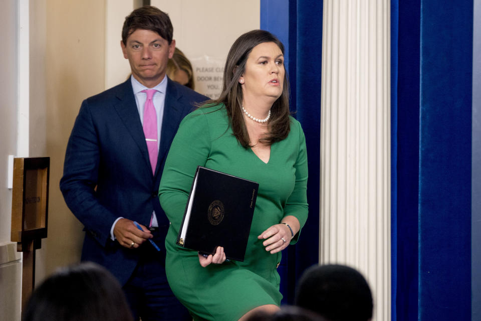 White House press secretary Sarah Huckabee Sanders, right, accompanied by White House Deputy White press secretary Hogan Gidley, left, arrives to read a statement from President Donald Trump announcing that he is removing the security clearance from former CIA Director John Brennan during the daily press briefing at the White House, Wednesday, Aug. 15, 2018, in Washington. (AP Photo/Andrew Harnik)