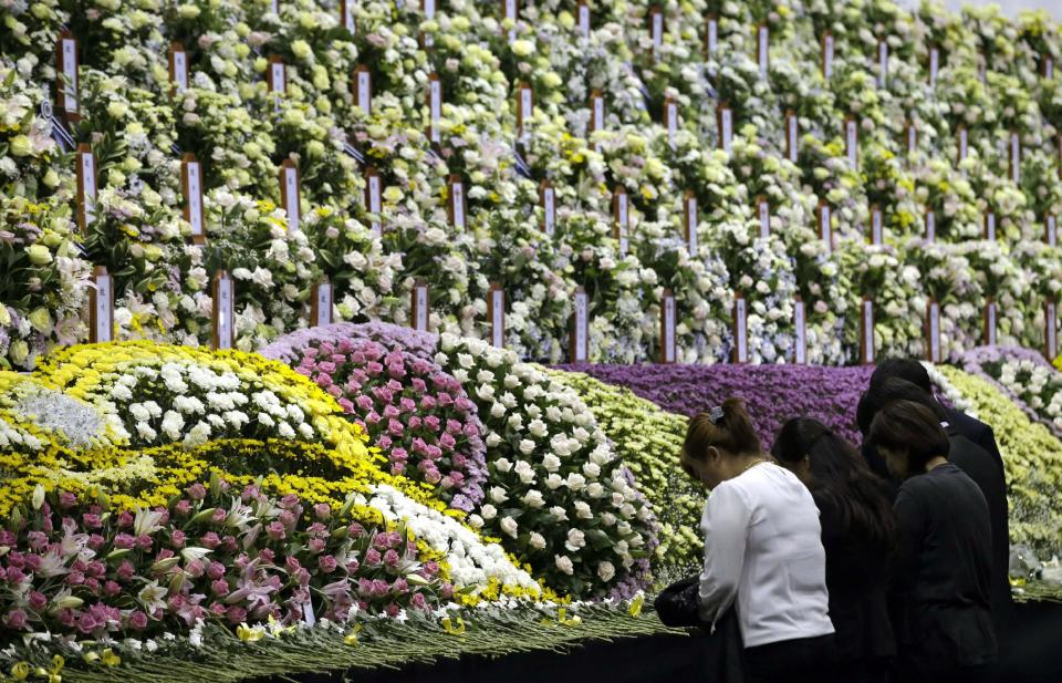 Relatives pay tribute to the victims of the sunken ferry Sewol at a group memorial altar in Ansan, south of Seoul, South Korea, Wednesday, April 30, 2014. Two weeks after the ferry sank off South Korea's southern cost, divers have recovered over 200 bodies from the wreckage, but they fought strong currents and floating debris inside the ship Wednesday as they searched for 90 passengers still missing.(AP Photo/Lee Jin-man)