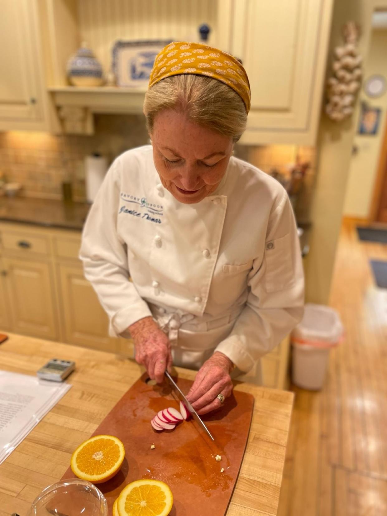 Chef Janice Thomas, owner of Savory Spoon Cooking School, cuts garnishes for a recipe.