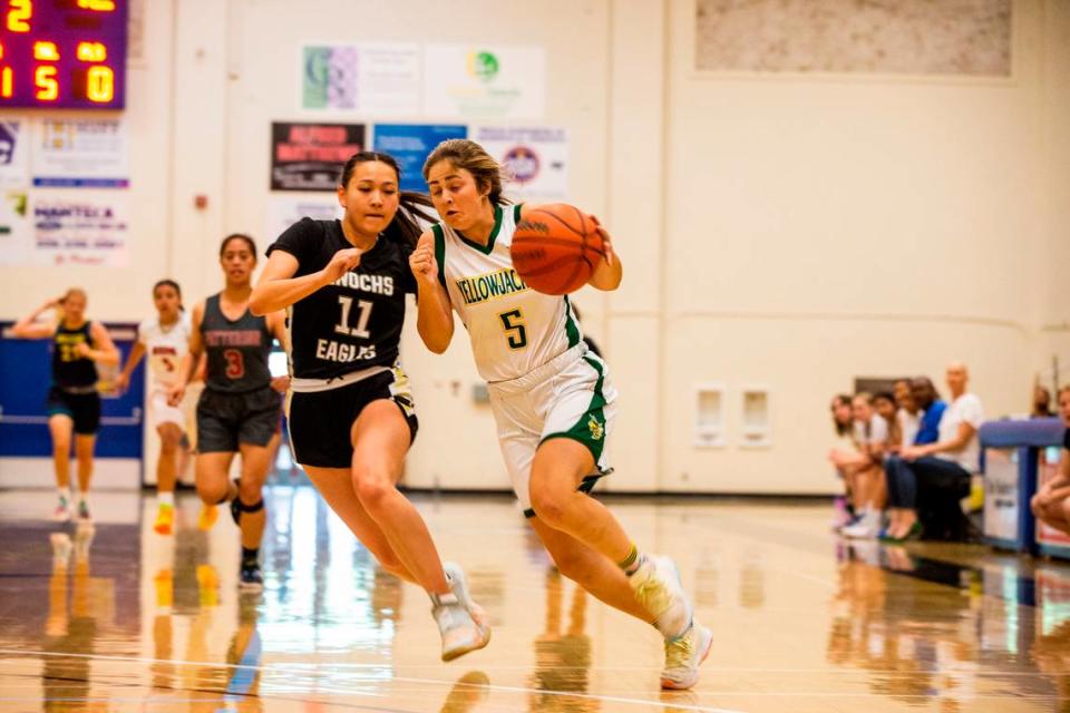 Emily Cogswell, of Hilmar High drives to the hoops with Lindsey Strong of Enochs High closing in during the Six-County All-Star Basketball Game at Modesto Junior College, in Modesto, Calif., Saturday, April 29, 2023.