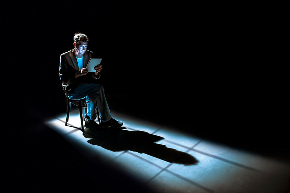 一名男子獨自坐在椅子上，看著手上的筆記本。攝：Bill Hinton / Getty Images