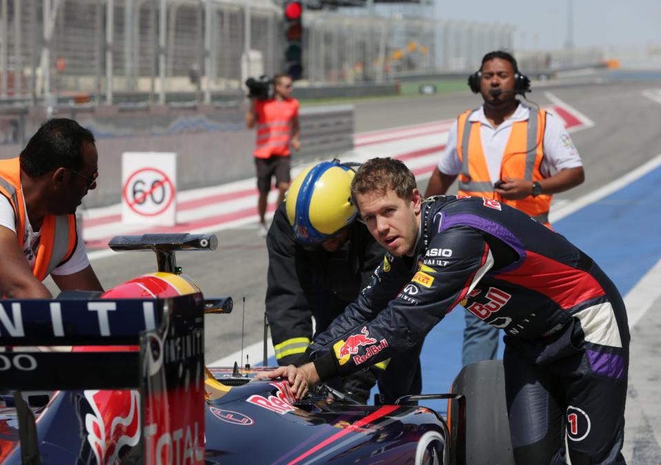 Formula One driver Sebastian Vettel of Red Bull Racing helps push his car after breaking down during pre-season testing at the Bahrain International Circuit in Sakhir, Bahrain, Saturday, March 1, 2014. (AP Photo/Hasan Jamali)