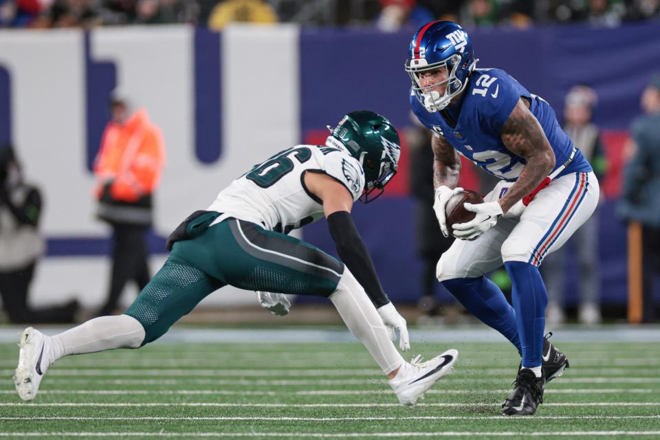 Jan 7, 2024; East Rutherford, New Jersey, USA; New York Giants tight end Darren Waller (12) makes a catch in front of Philadelphia Eagles safety Tristin McCollum (36) during the second half at MetLife Stadium. Mandatory Credit: Vincent Carchietta-USA TODAY Sports