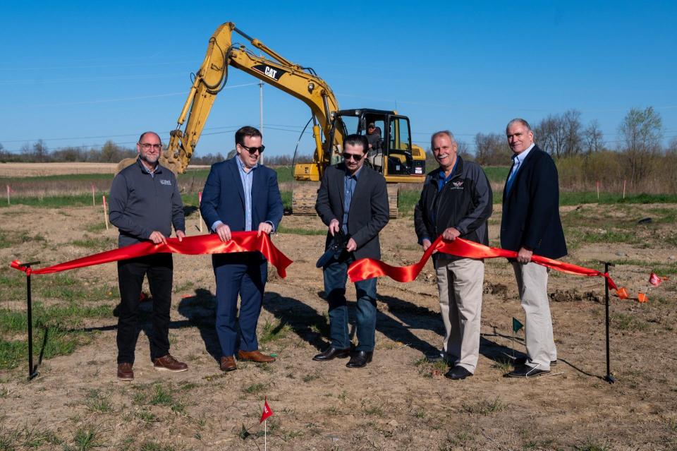 Hillsdale Mayor Adam Stockford cuts a ribbon at the groundbreaking ceremony for Portage-based developer Allen Edwin Homes’ workforce housing project on Hidden Meadows Drive in Hillsdale on Monday, April 22, 2024 (from left to right: Alan Beeker, Planning and Zoning Administrator for City of Hillsdale, Brian Farkas, Director of Workforce Housing for Allen Edwin Homes; Adam Stockford, Mayor of Hillsdale; John Condon, Chairman of City of Hillsdale Economic Development Corporation; Eric Moore, Chairman of City of Hillsdale Planning Commission).