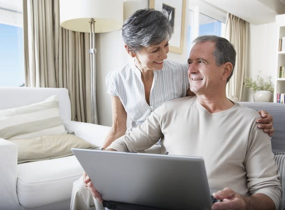 Woman sitting next to man with a laptop PC