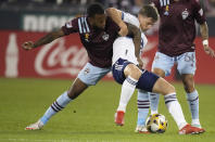 Colorado Rapids midfielder Kellyn Acosta, left, struggles with Vancouver Whitecaps midfielder Ryan Gould in the first half of an MLS soccer match Sunday, Sept. 19, 2021, in Commerce City, Colo. (AP Photo/David Zalubowski)