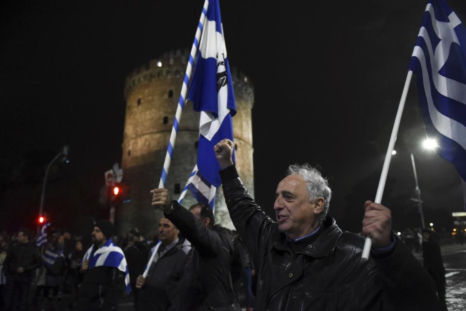 A man holding a Greek flag shouts slogans during a rally in front of the White Tower, a landmark of the northern Greek city of Thessaloniki, Friday, Dec. 14, 2018. Hundreds of people protest against government efforts to end a three-decade-old dispute with neighboring Macedonia as the Greek Prime Minister Alexis Tsipras will deliver a speech to party cadres and supporters. (AP Photo/Giannis Papanikos)