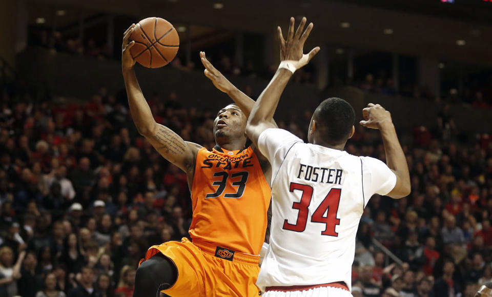 Oklahoma State's Marcus Smart (33) looks to score past Texas Tech's Alex Foster (34) during their NCAA college basketball game in Lubbock, Texas, Saturday, Feb, 8, 2014. (AP Photo/Lubbock Avalanche-Journal, Tori Eichberger) ALL LOCAL TV OUT