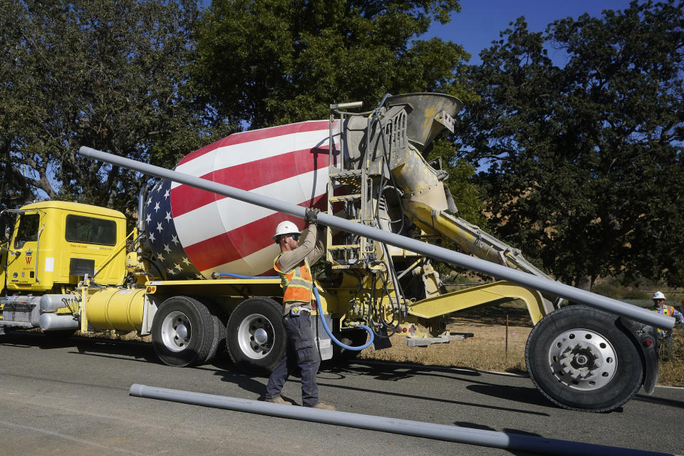 A truck drives past a Pacific Gas and Electric crew burying power lines in Vacaville, Calif., Wednesday, Oct. 11, 2023. PG&E wants to bury many of its power lines in areas threatened by wildfires. (AP Photo/Jeff Chiu)