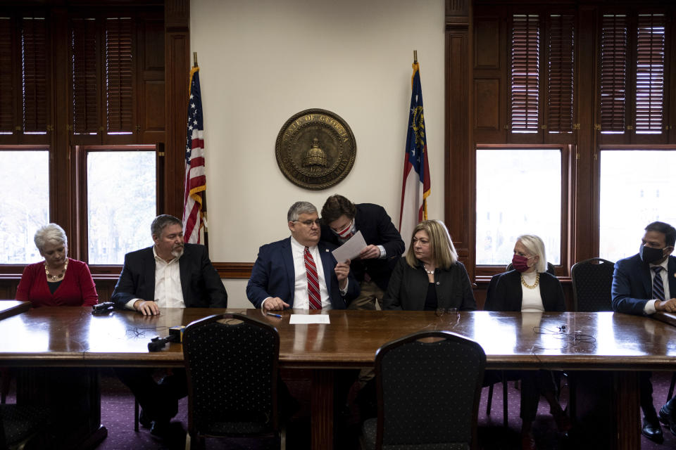 FILE - Robert Sinners, a staffer for Donald Trump’s 2020 reelection campaign, leans over to speak to then-Georgia Republican Party Chairman David Shafer, center, during a meeting of Republican electors who cast votes for Trump and Vice President Mike Pence at the Georgia Capitol, Dec. 14, 2020, in Atlanta,. The meeting of the electors has become a key element in the prosecution of Trump and 18 others in Georgia. Smith is one of the four people present that day who was indicted by a Fulton County grand jury in August 2023 on charges that he conspired to illegally overturn Democrat Joe Biden's win in Georgia. (AP Photo/Ben Gray, File)