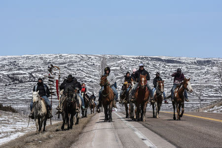 A group of the Fort Laramie treaty riders head out in the morning along the local highway on the Cheyenne River Reservation outside of Bridger, South Dakota, U.S., April 16, 2018. REUTERS/Stephanie Keith