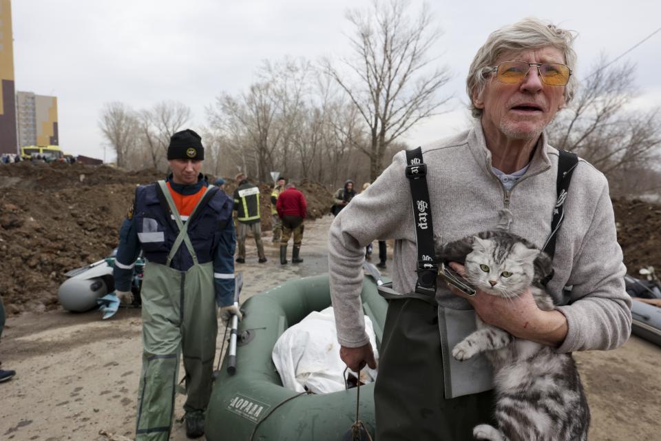 A man hugs his pet as he pulls a boat with emergency workers in a flooded area in Orenburg, Russia, Wednesday, April 10, 2024. Russian officials are scrambling to help homeowners displaced by floods, as water levels have risen in the Ural River. The floods in the Orenburg region near Russia's border with Kazakhstan sparked the evacuation of thousands of people following the collapse of a dam on Saturday. (AP Photo)