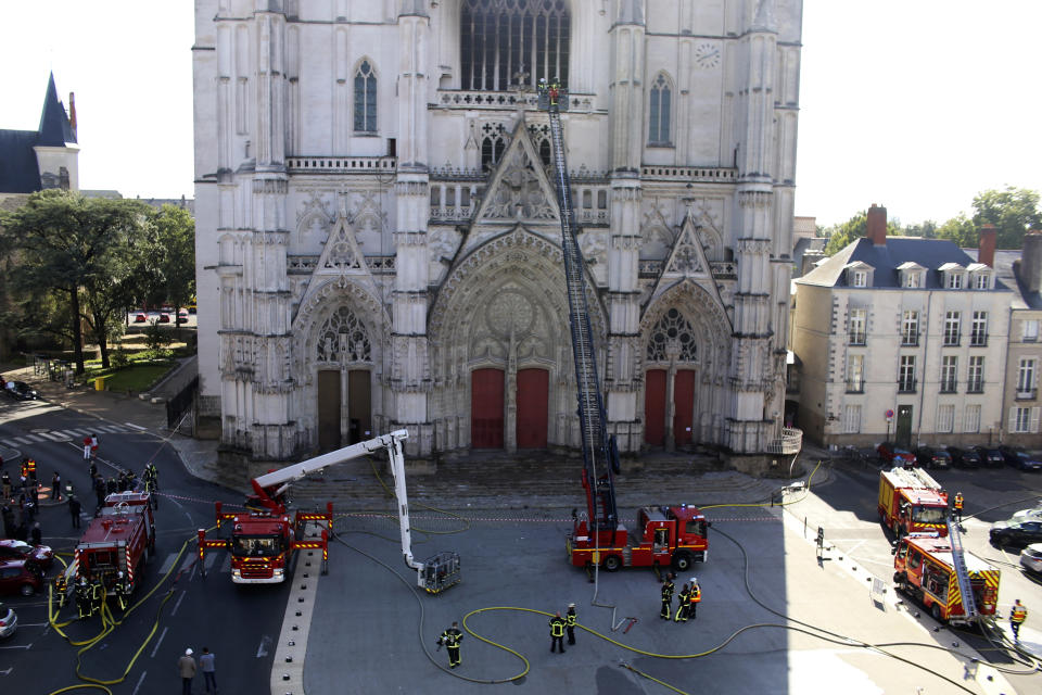 Fire fighters brigade work to extinguish the blaze at the Gothic St. Peter and St. Paul Cathedral, in Nantes, western France, Saturday, July 18, 2020. The fire broke, shattering stained glass windows and sending black smoke spewing from between its two towers of the 15th century, which also suffered a serious fire in 1972. The fire is bringing back memories of the devastating blaze in Notre Dame Cathedral in Paris last year that destroyed its roof and collapsed its spire and threatened to topple the medieval monument. (AP Photo/Romain Boulanger)