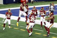 Washington Football Team's Montez Sweat, second from left, and Ryan Kerrigan (91) celebrate Sweat's interception of a pass by Dallas Cowboys' Andy Dalton that Sweat ran back for a touchdown during the second half of an NFL football game in Arlington, Texas, Thursday, Nov. 26, 2020. Kamren Curl (31), Jeremy Reaves (39), Daron Payne (94), Jon Bostic (53) and Chase Young (99) run to join the celebration. (AP Photo/Roger Steinman)