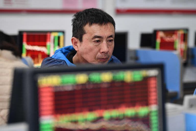 Un inversor mira las pantallas que muestran los movimientos del mercado de valores en una compañía de valores en Fuyang, en la provincia oriental china de Anhui, el 17 de enero de 2024