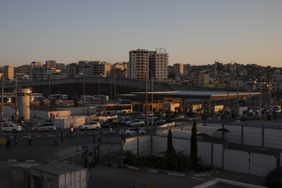 In this Thursday, July 11, 2019 photo, cars pass the Qalandia crossing between the West Bank city of Ramallah and Jerusalem. Israel’s military has invested tens of millions of dollars to upgrade West Bank crossings and ease entry for Palestinian workers. But while the upgrades may have eased crossing for Palestinians entering Israeli daily for work, critics say they are a sign of the ossification of Israel’s 52-year occupation of the West Bank and slam the military’s use of facial recognition technology as problematic. (AP Photo/Sebastian Scheiner)