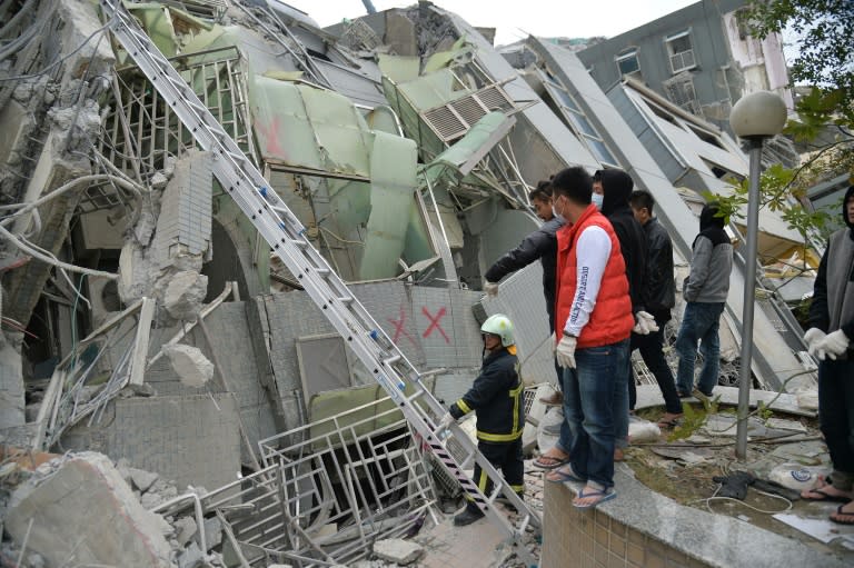 Rescue personnel search through debris at the site of a collapsed building in the southern Taiwanese city of Tainan following a strong 6.4-magnitude earthquake that struck the island early on February 6, 2016