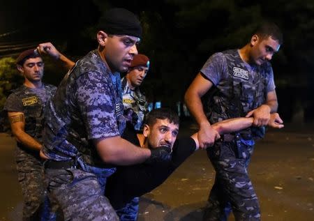 Police officers detain a man during a clash with demonstrators who had gathered in a show of support for gunmen holding several hostages in a police station in Yerevan, Armenia. REUTERS/Hayk Baghdasaryan/Photolure