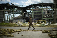 A Ukrainian serviceman walks past a gypsum manufacturing plant destroyed in a Russian bombing in Bakhmut, eastern Ukraine, eastern Ukraine, Saturday, May 28, 2022. Fighting has raged around Lysychansk and neighbouring Sievierodonetsk, the last major cities under Ukrainian control in Luhansk region. (AP Photo/Francisco Seco)