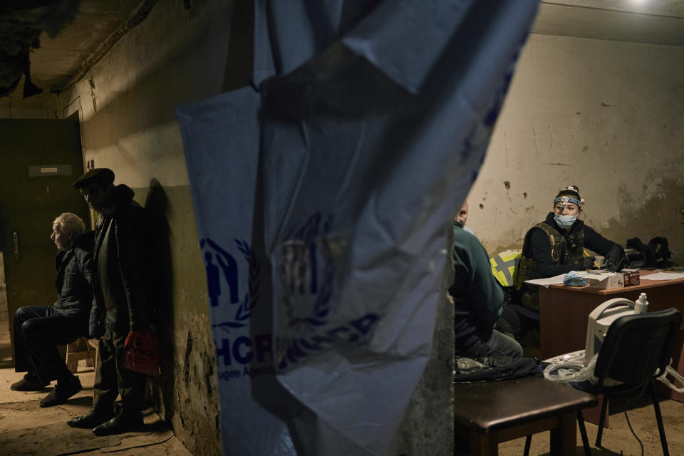 Local residents wait for their turn to get a medical aid from charitable organization Frida volunteers in a basement in Bakhmut, the site of the heaviest battles with the Russian invaders, in the Donetsk region, Ukraine, Sunday, Dec. 18, 2022. Ukrainian-Israeli mission FRIDA provides emergency medical relief to the most vulnerable of Ukrainian citizens who have suffered from the Russian aggression and are in need of medical care. (AP Photo/LIBKOS)