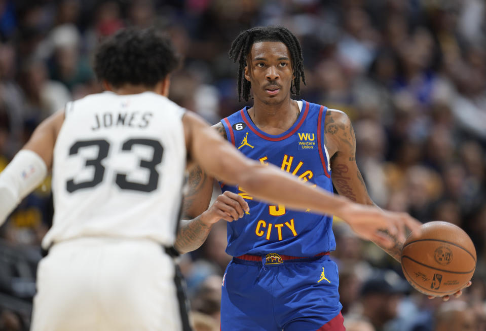 Denver Nuggets guard Bones Hyland, right, looks to pass the ball as San Antonio Spurs guard Tre Jones defends in the second half of an NBA basketball game Saturday, Nov. 5, 2022, in Denver. (AP Photo/David Zalubowski)