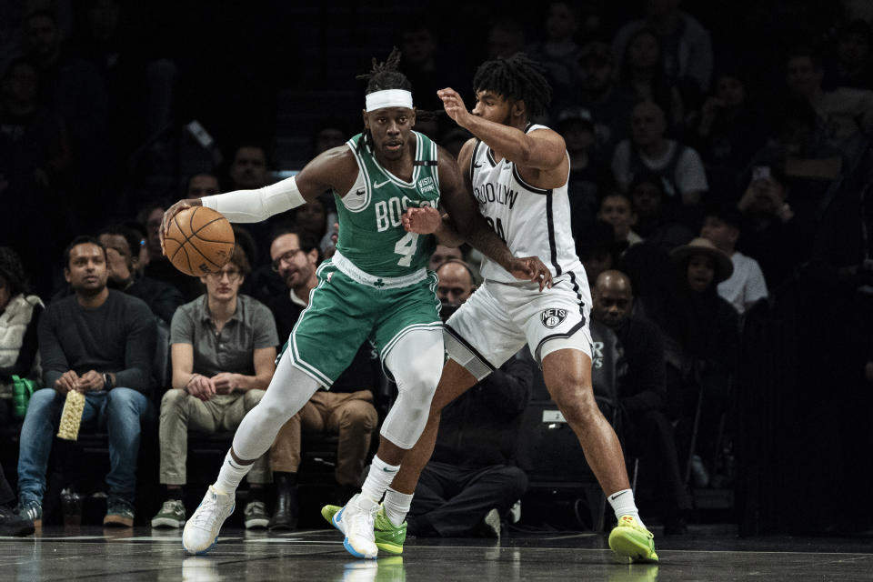 Boston Celtics guard Jrue Holiday (4) is defended by Brooklyn Nets guard Cam Thomas during the first half of an NBA basketball game in New York, Tuesday, Feb. 13, 2024. (AP Photo/Peter K. Afriyie)