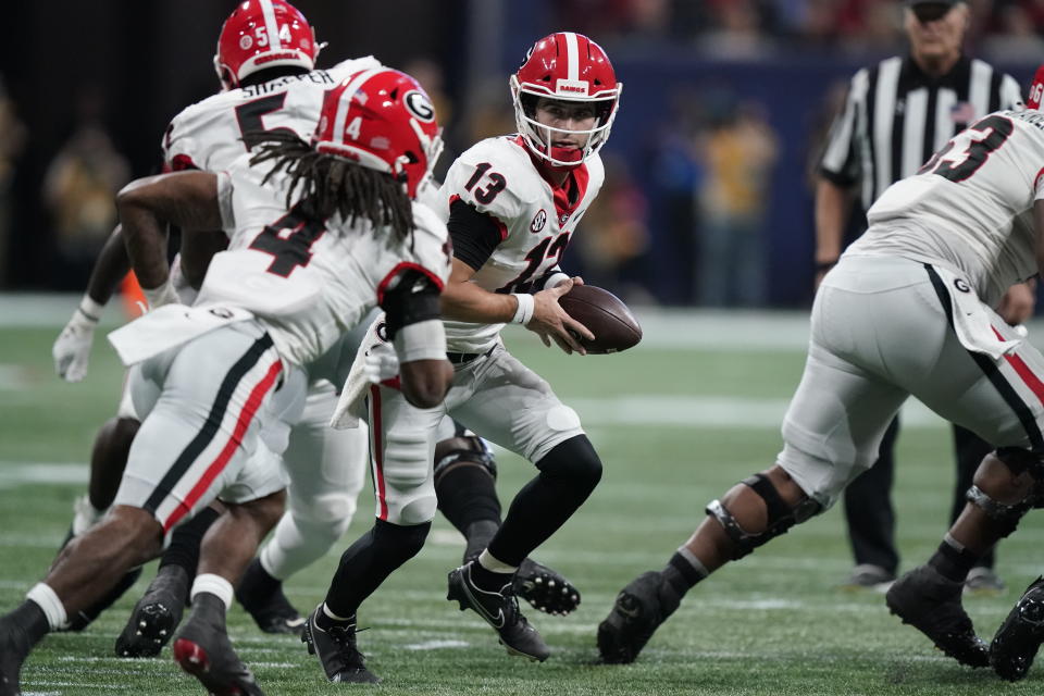 Georgia quarterback Stetson Bennett (13) looks to hand the ball off against Alabama during the first half of the Southeastern Conference championship NCAA college football game, Saturday, Dec. 4, 2021, in Atlanta. (AP Photo/Brynn Anderson)
