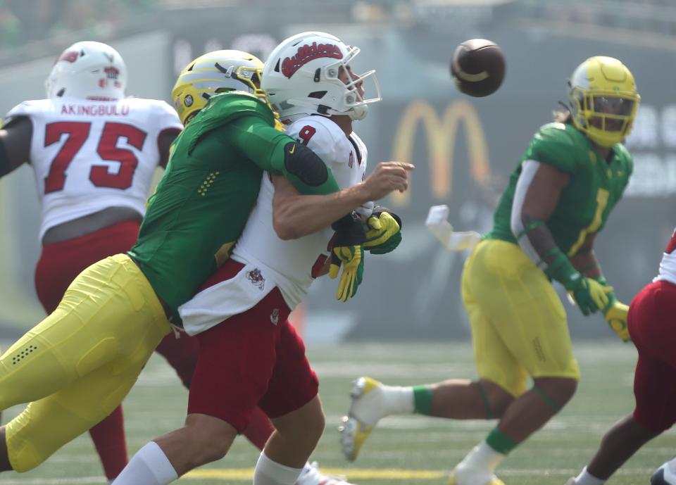 Oregon's Kayvon Thibodeaux, left, sacks Fresno State quarterback Jake Haener forcing a turnover during the first quarter at Autzen.