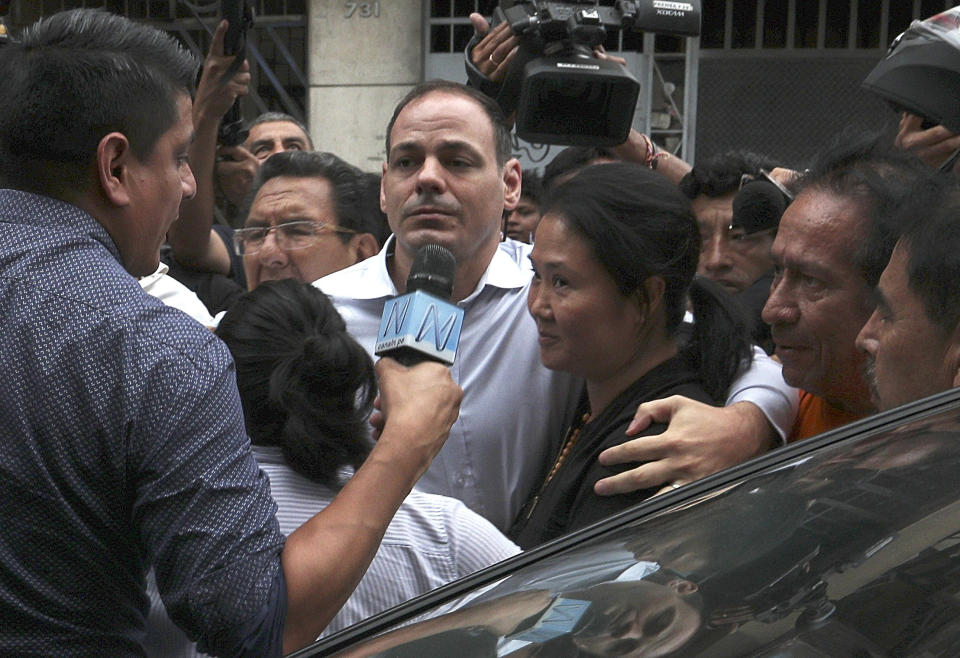 Keiko Fujimori, the daughter of Peru's former President Alberto Fujimori and opposition leader with her husband Mark Vito Villanela, enters to the courtroom in handcuffs in Lima, Peru, Tuesday, Jan. 28, 2020. In a court session a judge decided she must return to preventive detention pending a corruption investigation. (AP Photo/Martin Mejia)