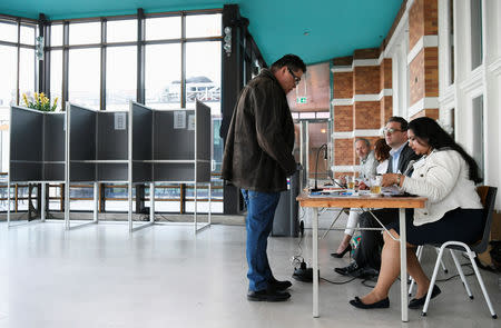 Election staff process a voter arriving at a polling place for the European elections, at the Kurhaus in Scheveningen, Netherlands May 23, 2019. REUTERS/Piroschka van de Wouw