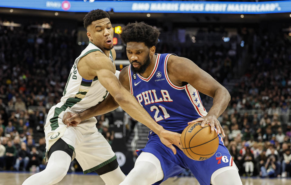 Philadelphia 76ers center Joel Embiid (21) drives against Milwaukee Bucks forward Giannis Antetokounmpo, left, during the first half of an NBA basketball game Sunday, April 2, 2023, in Milwaukee. (AP Photo/Jeffrey Phelps)